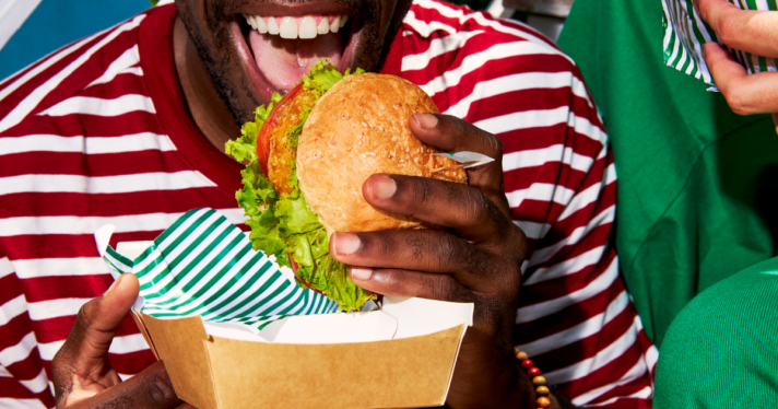 A man eating a plant-based burger.