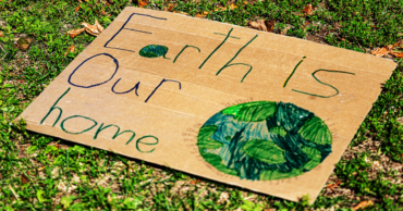 A sign that says "Earth is our home"