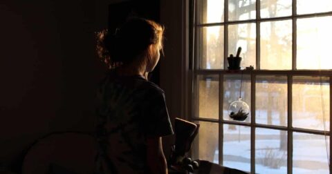 girl looking through a window