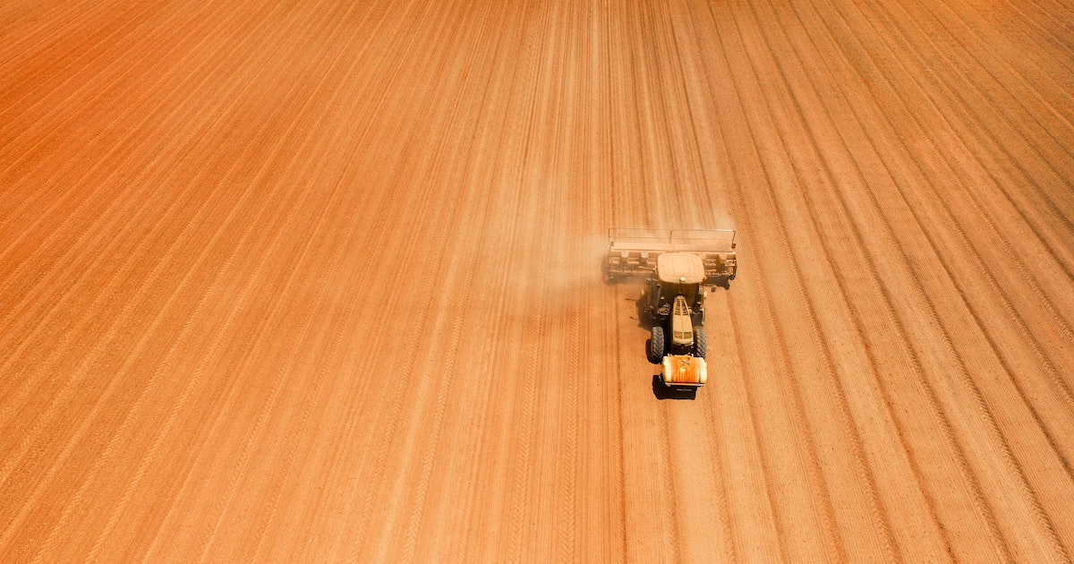 aerial view of tractor sowing in an arid field