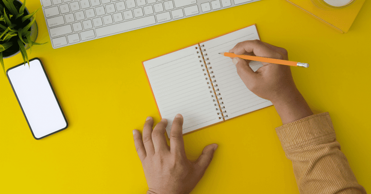 person writing, yellow background