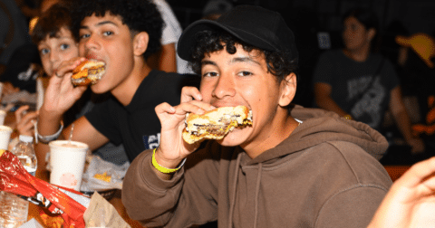 A group of kids eating burgers