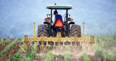 Farm bill explainer. Image shows man in tractor on farm.
