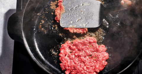Two burger patties being cooked