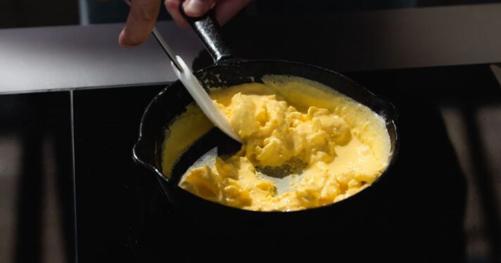 image of scrambled eggs in a cast iron pan, eggs made with precision fermentation