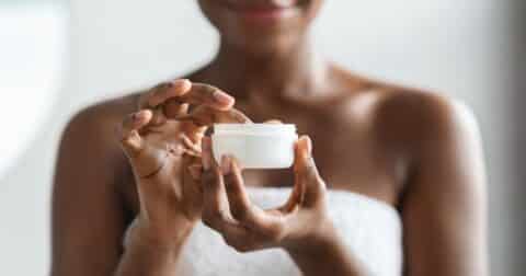 Closeup of a woman holding moisturizer