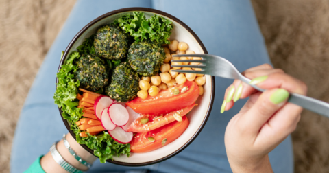 A bowl of plant-based food, including various veggies and chickpeas