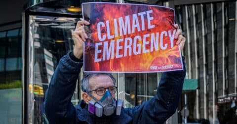 A man holds a sign that says 