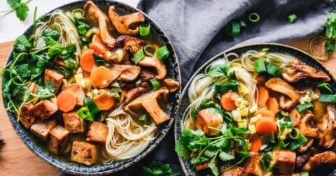 Two bowls of vegan pho with spicy pan-fried tofu and shiitake mushrooms