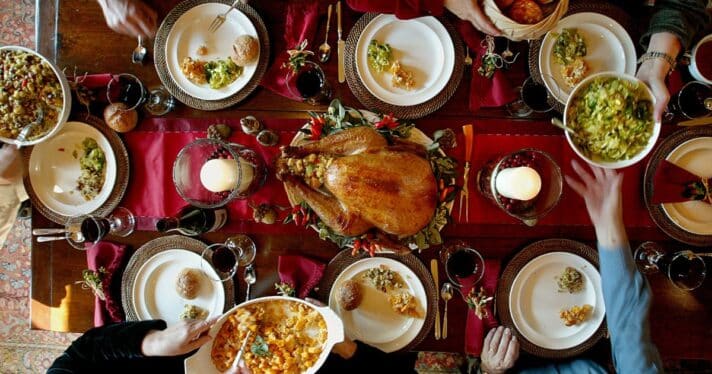 A table with Thanksgiving dinner stables, including turkey, stuffing and mac and cheese