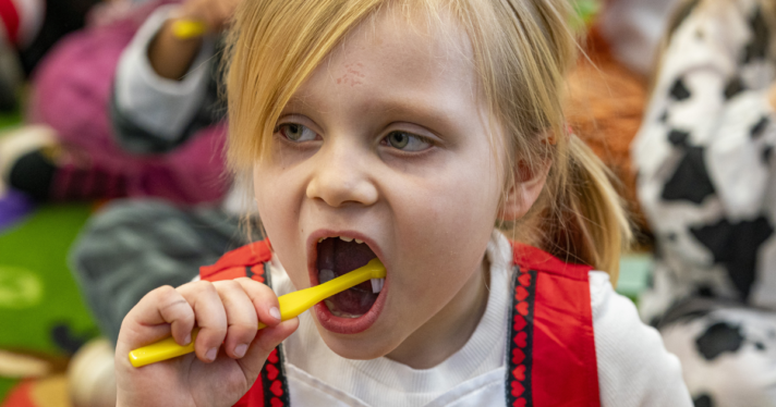 A young child brushing their teeth