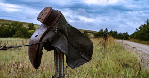 A cowboy boot hanging on wire