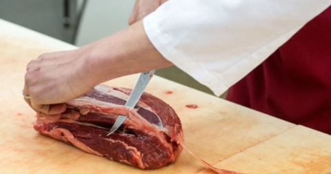 A person cutting meat