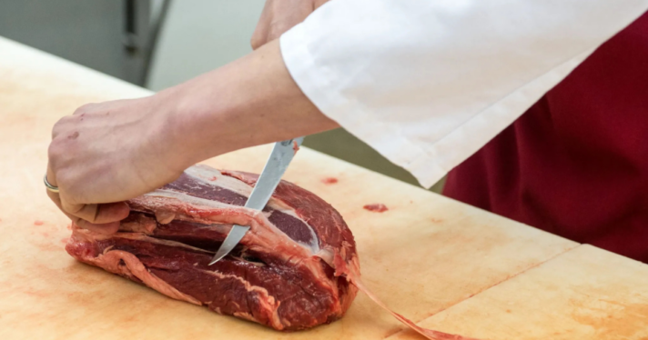 A person cutting meat