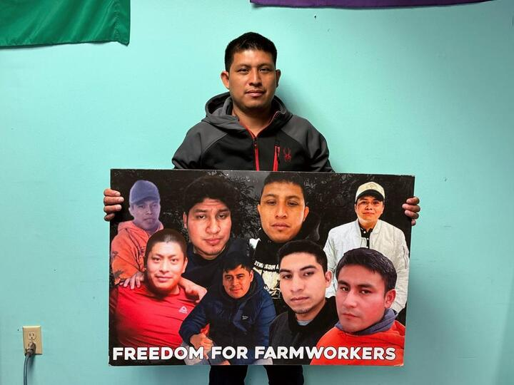 José Edilberto Molina-Aguilar holds a poster depicting the eight farmworkers detained at Pleasant Valley Farms, including Jesus Mendez Hernandez and Adrian Zunun-Joachin. 
