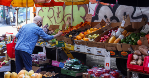 A man shops at a grocery stand