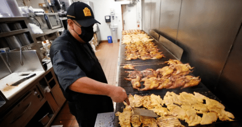 Meat laid being cooked across multiple grills
