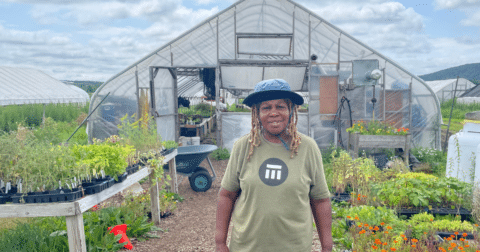 A woman standing in front of her farm