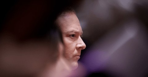 A man's focused face in a crowd