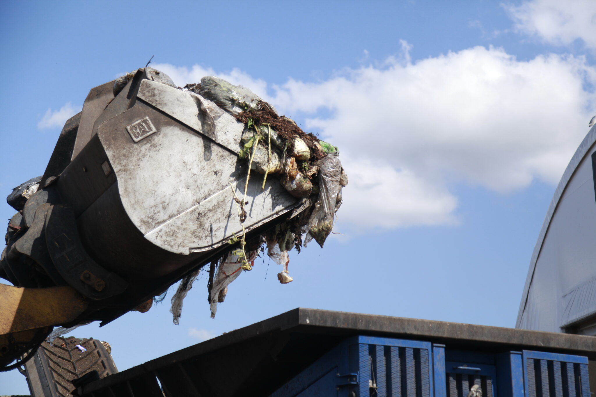 Food and yard waste being lifted in a landfill
