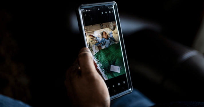 A person holding up a picture on their phone