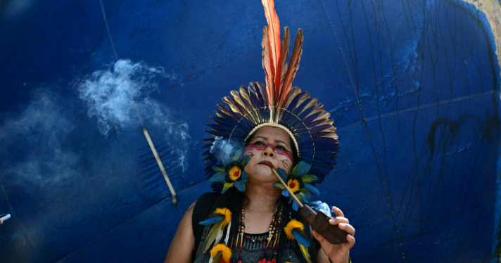 An indigenous woman smoking a pipe