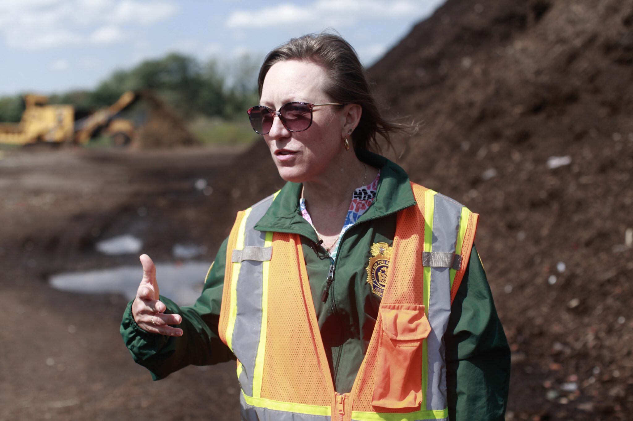 A woman talking with compost in the background