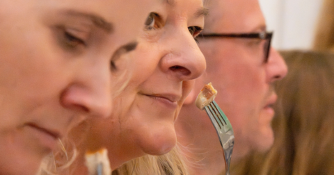 Three people sampling different sausages at Oktoberfest