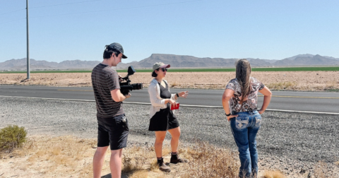 Three people shooting an interview in an arid setting