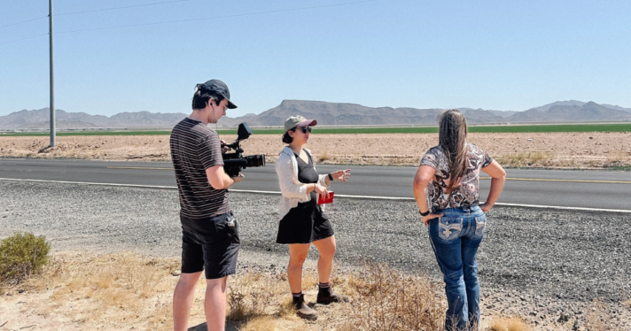 Three people shooting an interview in an arid setting