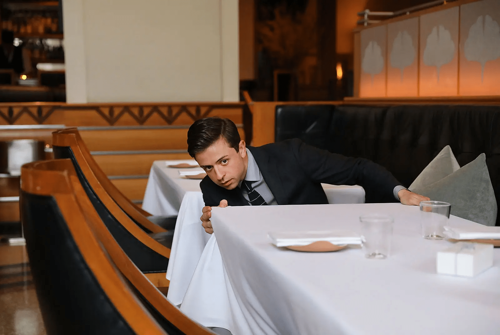 A worker in a restaurant examining a table cloth