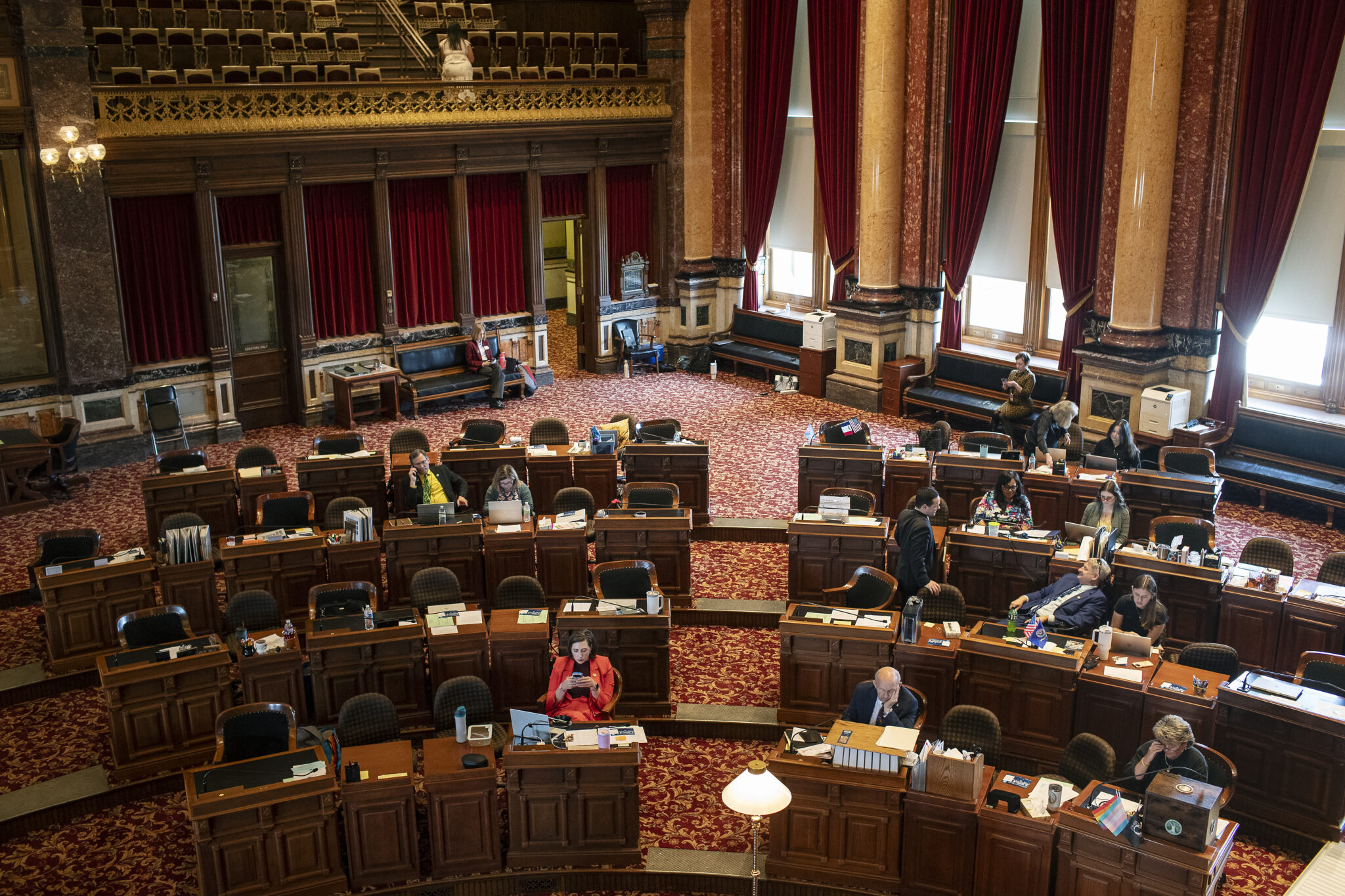 State Senators sitting at desks on the floor of the State Senate
