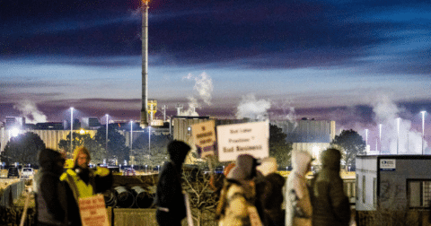 A group of people striking outside of a beef production facility