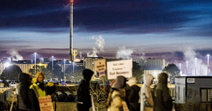 A group of people striking outside of a beef production facility