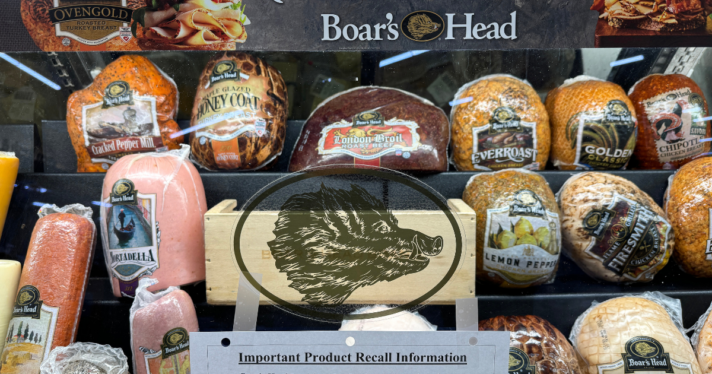 A window full of deli meat with a recall sign