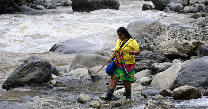 A person walking along a river bank