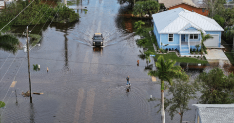 A person walking through flood waters in a neighborhood in Florida after Hurricane Milton